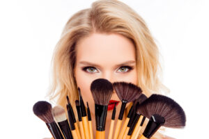 Elegancka para w świątecznym wnętrzu; kobieta w czerwonej sukience prezentuje makijaż wieczorowy wykonany w studio Syrenka Toruń.