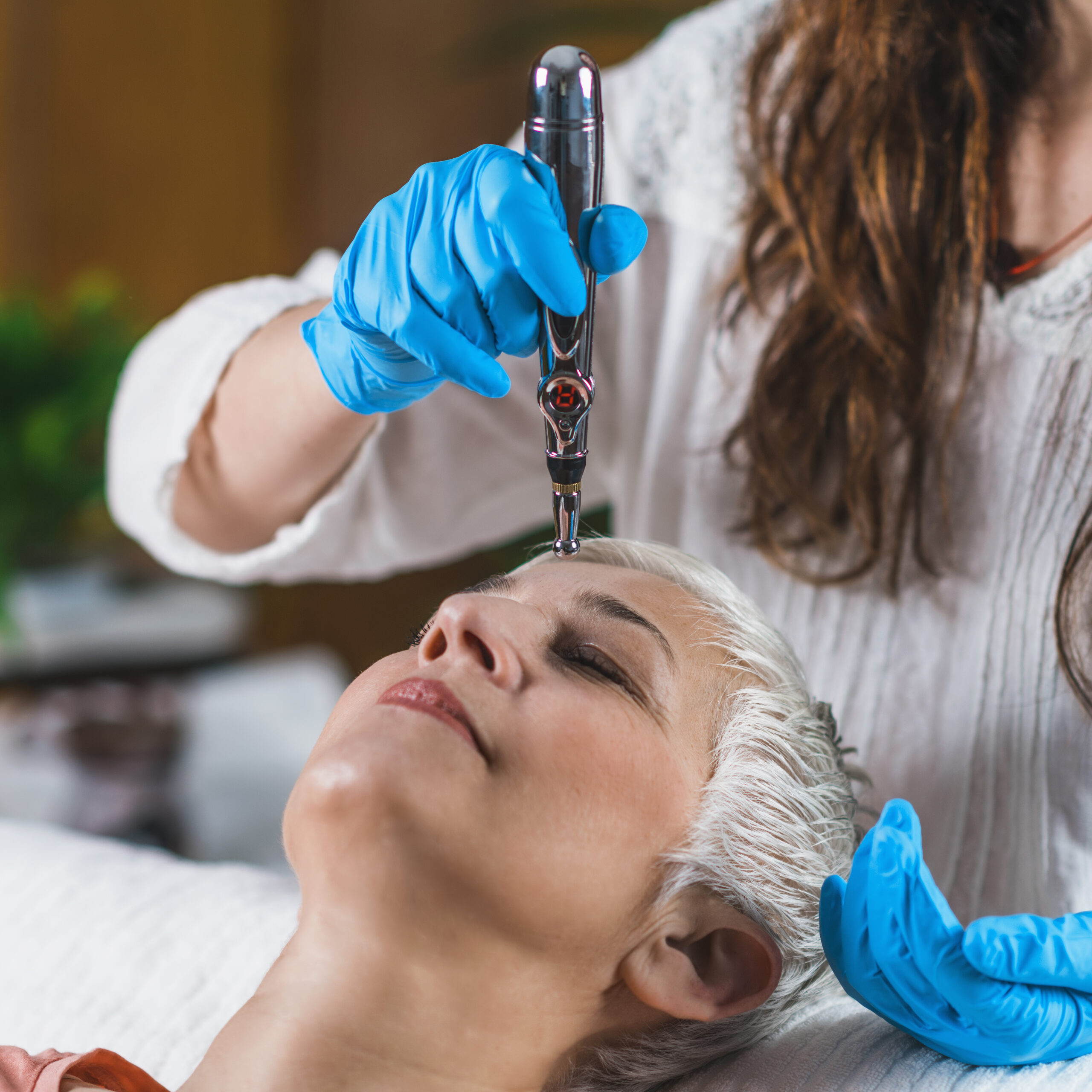 Kobieta podczas zabiegu mezoterapii mikroigłowej; kosmetolog wykonuje delikatne nakłucia na skórze twarzy.